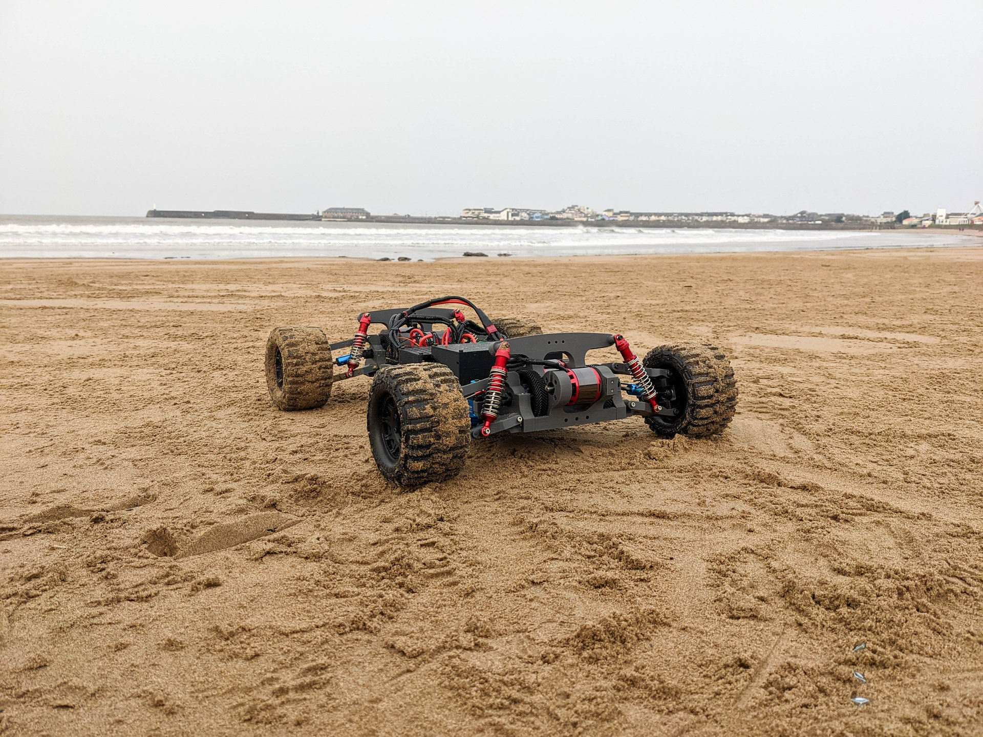 Raptor II, a 3D-printed all-wheel-drive RC car, on a sandy beach